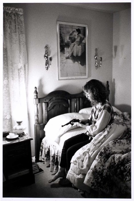Woman on bed with gun